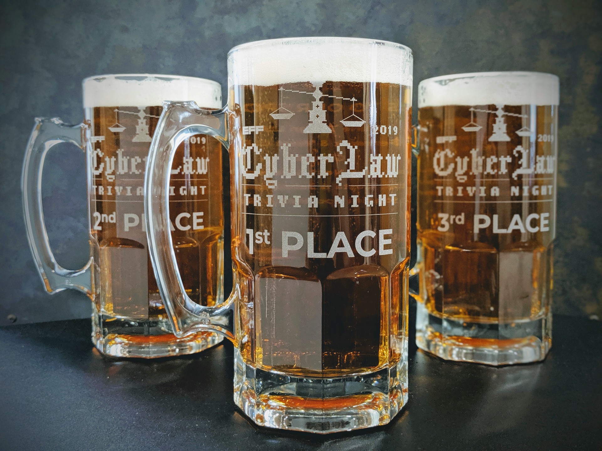 The aforementioned coveted Cyberlaw Quiz Cups that are actually glass beer steins... Photo of the coveted Cyberlaw Quiz Cups, which are actually large glass steins, filled with beer, with 1st place in the center, 2nd place to the left, and 3rd place to the right.