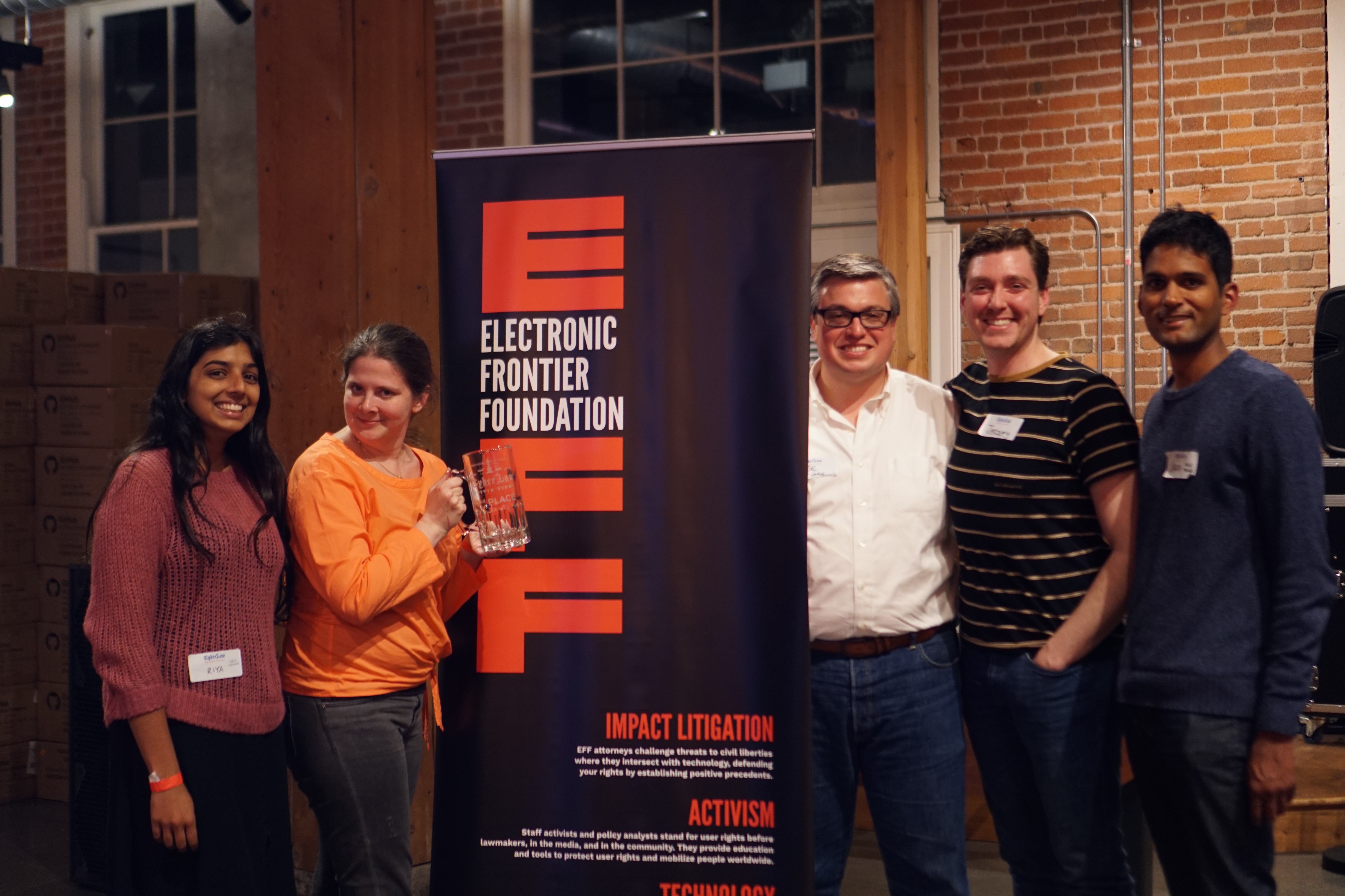 "DT FUCT" "DT FUCT". This is a photo of several people holding glass 2nd place mugs standing next to an EFF banner