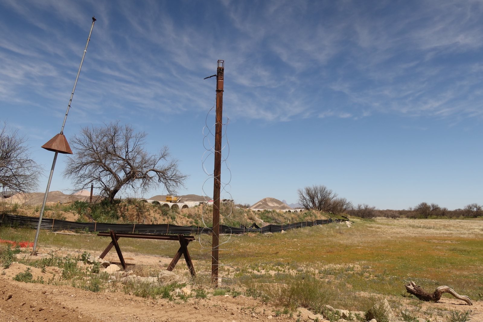 EFF A desert scene with a rust-colored pole surrounded by razor wire.