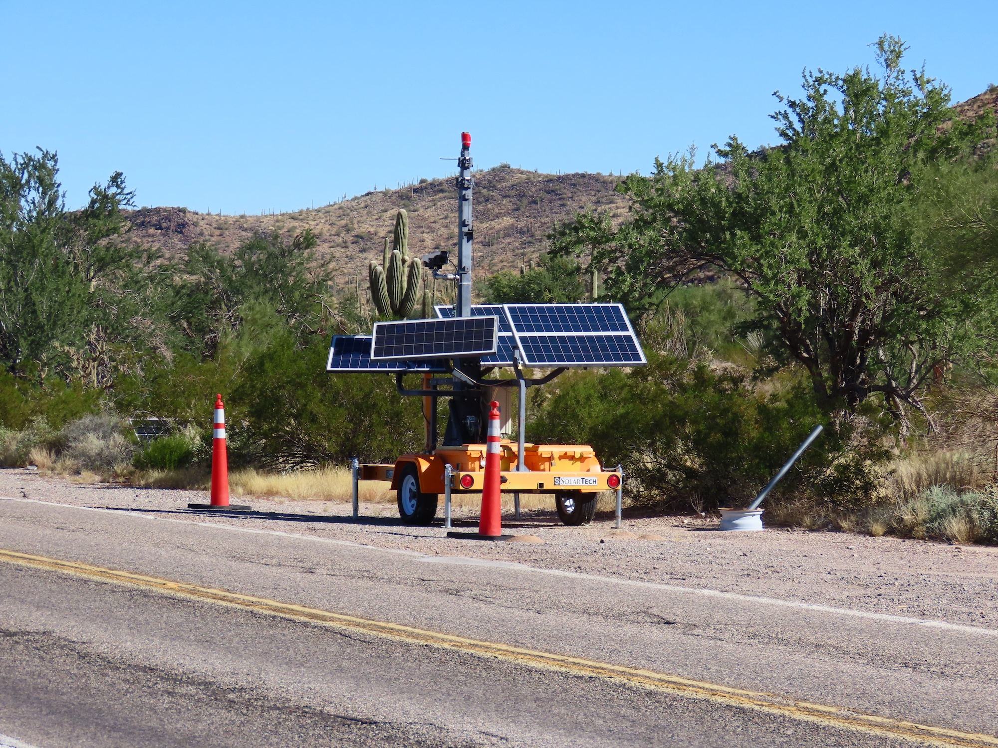 An orange trailer with ALPR cameras by the side of the road.